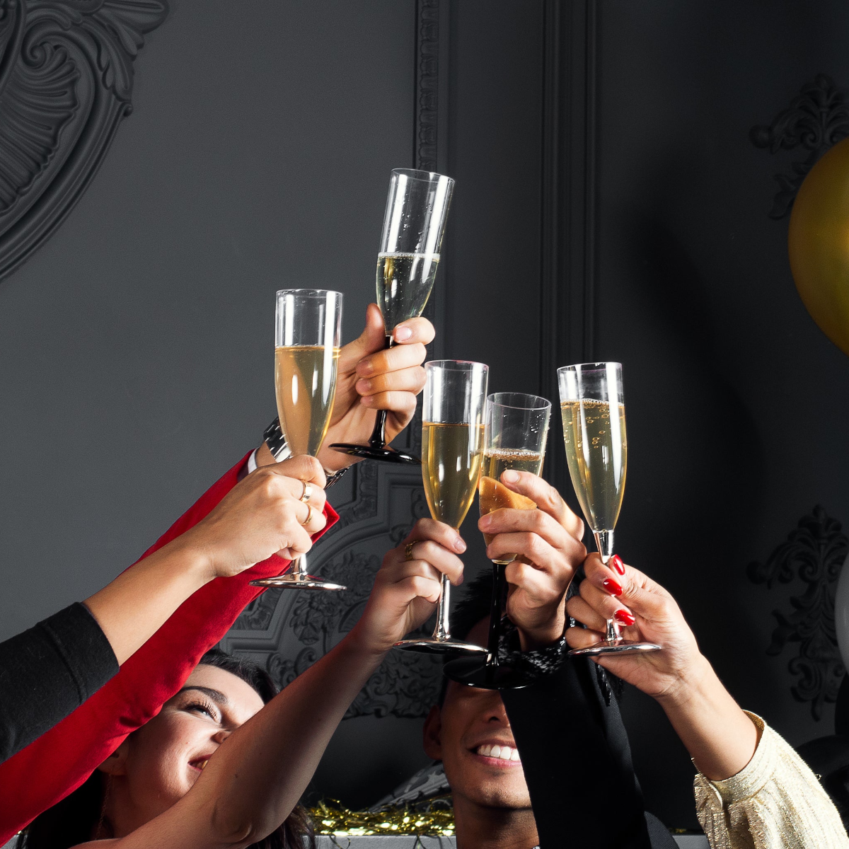 People toasting with champagne glasses against a dark background